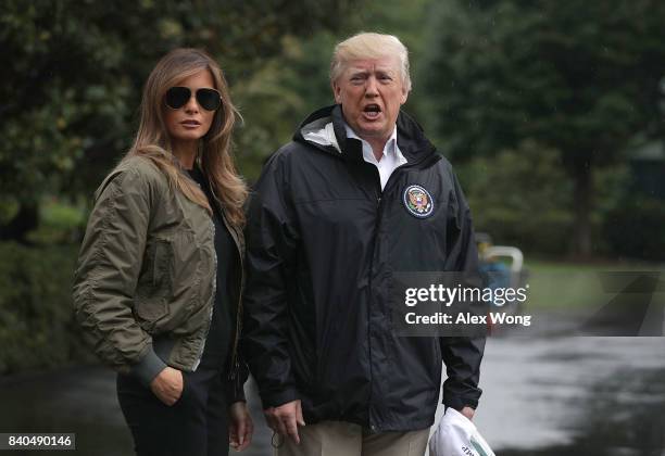 President Donald Trump speaks to members of the media briefly as first lady Melania Trump looks on prior to their Marine One departure from the White...