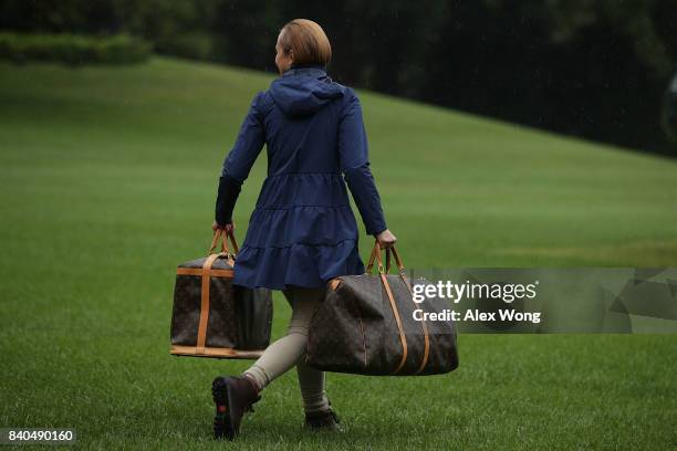 Presidential aide brings luggage bags to the Marine One prior to the departure of President Donald Trump and first lady Melania Trump from the White...