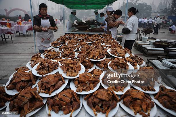 Chefs prepare dishes for residents of a village prior to a dinner held to mark the 30th anniversary of China's reform initiative on December 16, 2008...