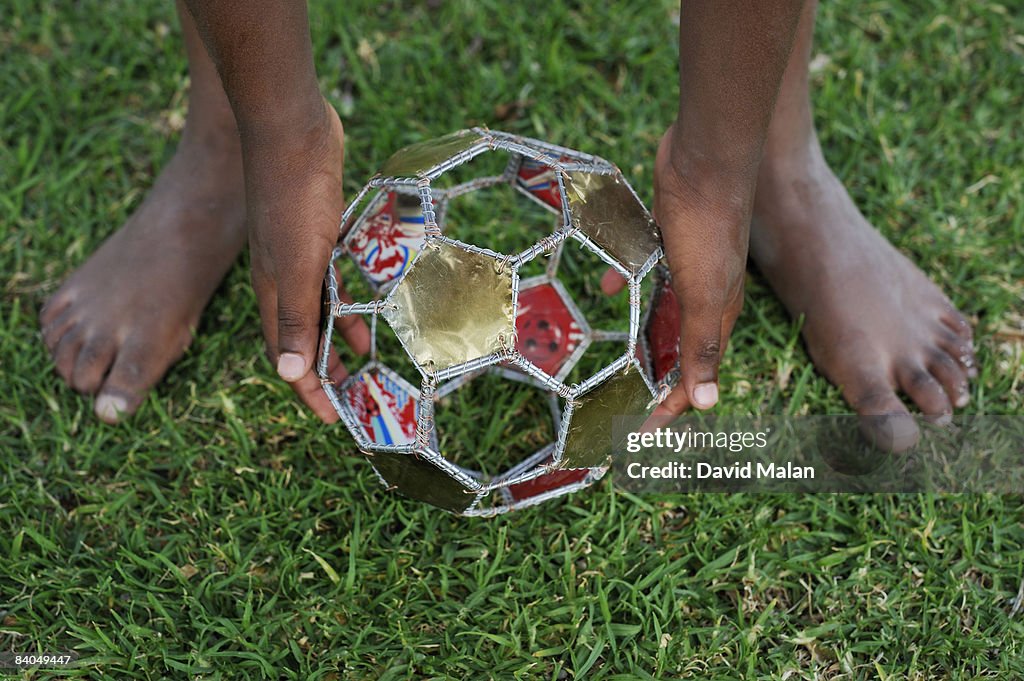 Boys hands & feet with wire soccer ball
