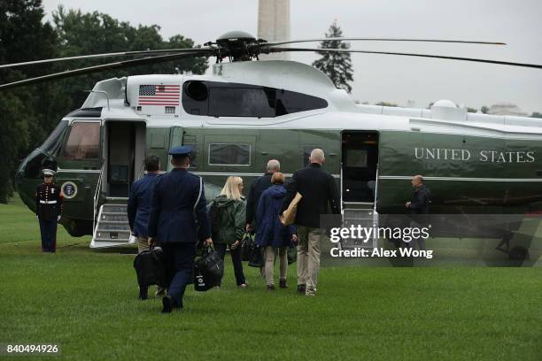 White House Chief of Staff John Kelly and other presidential aides walk on the South Lawn towards Marine One prior to a departure from the White...