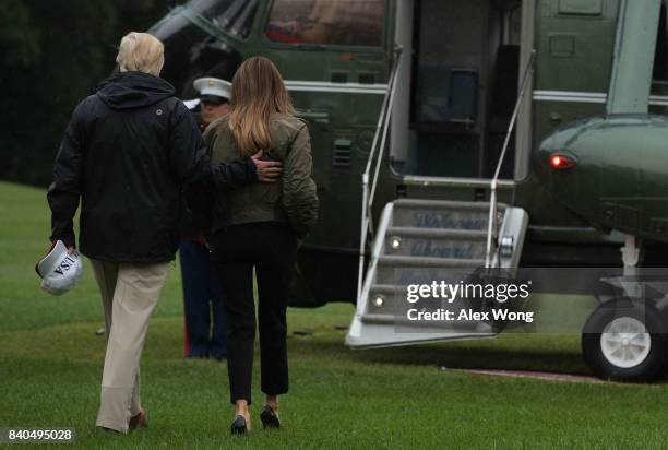 President Donald Trump and first lady Melania Trump walk on the South Lawn towards Marine One prior to their departure from the White House August...