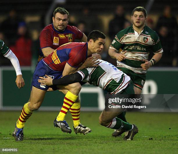 Dan Carter of Perpignan is tackled by Aaron Mauger of Leicester Tigers during the Heineken Cup match between Perpignan and Leicester Tigers at Stade...