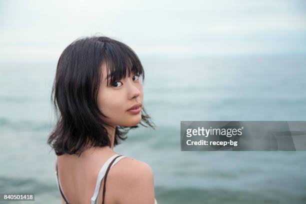 lonly junge frau am meer - beautiful asian ladies stock-fotos und bilder
