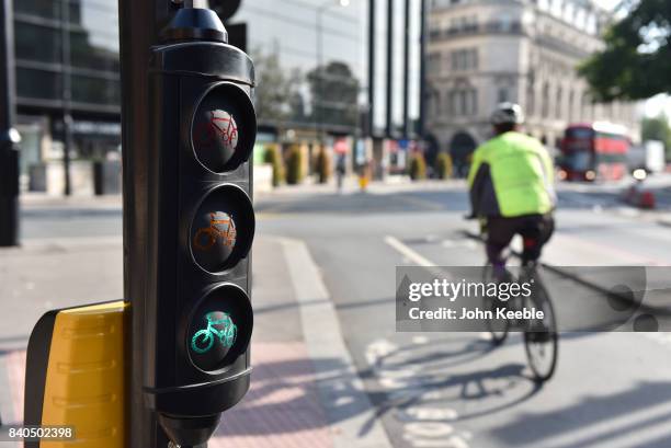 Cyclist rides pass a set of cycle traffic lights on the East-West Cycle Superhighway near Tower Hill on August 28, 2017 in London, England.