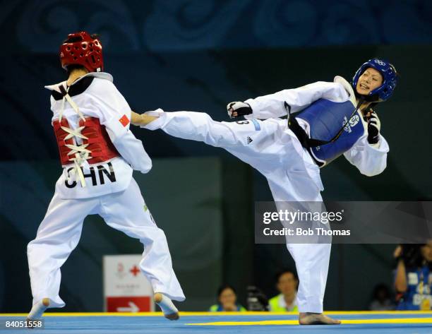 Shu-Chun Yang of Taipei against Jingyu Wu of China during the Women's taekwondo -49kg at the University of Science and Technology Gymnasium during...