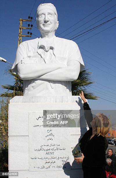 An unidentified woman points towards the bust of Michael DeBakey , the world-famous cardiovascular surgeon who pioneered such now-common procedures...