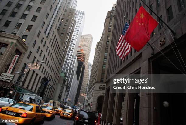 The flag of the People's Republic of China hangs next to an American flag outside the Goldman Sachs headquarters building December 16, 2008 in New...