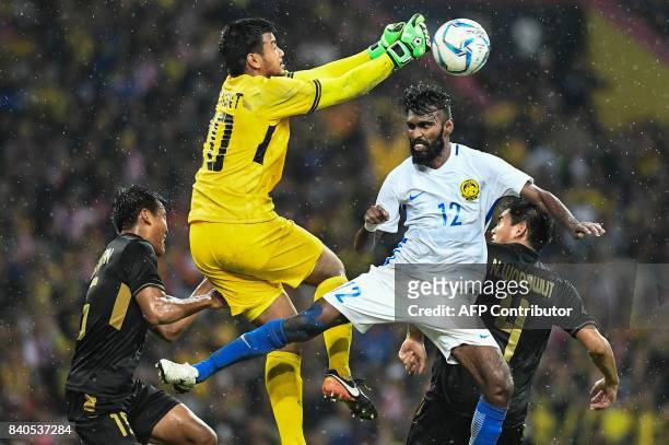 Malaysia's Thanabalan Nadarajah fights for the ball against Thailand's goalkeeper Nont Muangngam during their men's football finals match at the 29th...