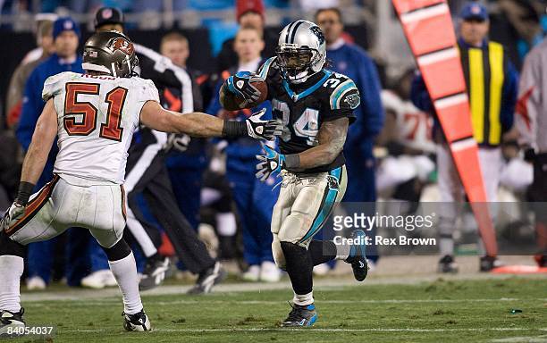 DeAngelo Williams of the Carolina Panthers works to get by Barrett Ruud of the Tampa Bay Buccaneers during the second half on December 8, 2008 at...
