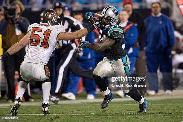 DeAngelo Williams of the Carolina Panthers works to get by Barrett Ruud of the Tampa Bay Buccaneers during the second half on December 8, 2008 at...