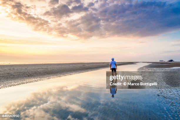 tourist at the wadden sea at sunset. st. peter-ording, germany. - wadden sea stock pictures, royalty-free photos & images