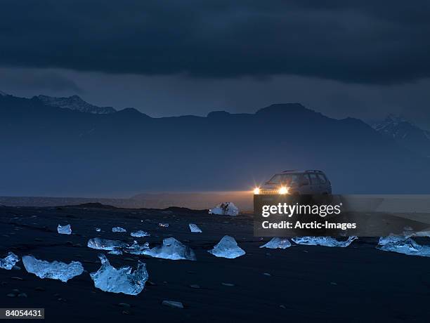 jeep with ice on black sand beach, iceland - breidamerkurjokull glacier stockfoto's en -beelden