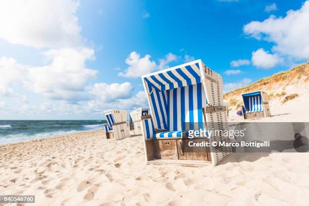strandkorb beach baskets. sylt island, germany. - hooded beach chair stock pictures, royalty-free photos & images