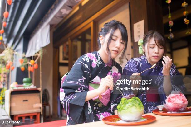 duas jovens irmãs yukata comendo kakigori sobremesa de gelo - matsuri - fotografias e filmes do acervo