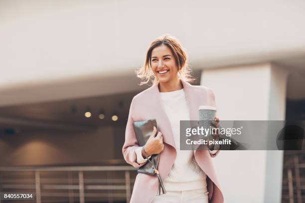 heureuse femme d'affaires avec une tasse de café - sac à main blanc photos et images de collection