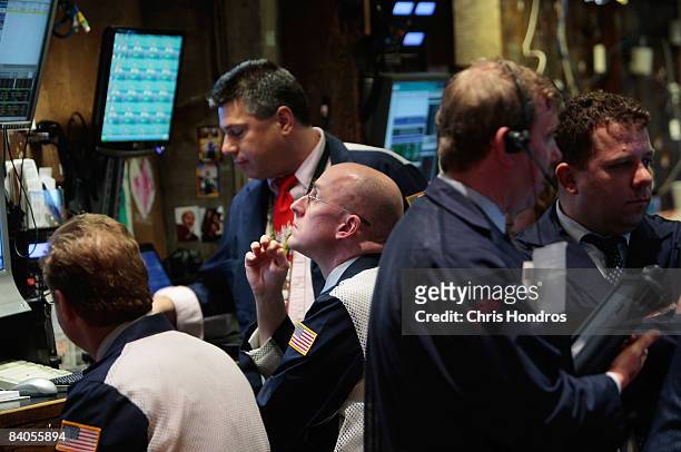 Financial professionals on the floor of the New York Stock Exchange work after hearing news of the Federal Reserve's rate cut December 16, 2008 in...