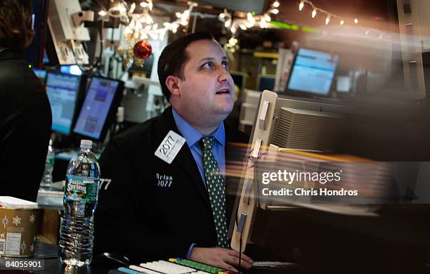 Financial professional works at a computer terminal on the floor of the New York Stock Exchange after the Federal Reserve's rate cut December 16,...