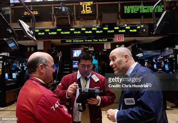 Financial professionals talk on the floor of the New York Stock Exchange after the Federal Reserve's rate cut December 16, 2008 in New York City. The...