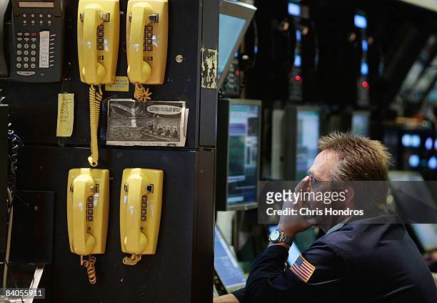 Financial professional works at a computer terminal on the floor of the New York Stock Exchange after the Federal Reserve's rate cut December 16,...