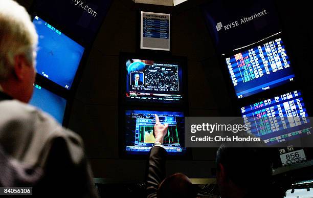 Financial professional points at a television screen as the news of Federal Reserve's rate cut is announced on the floor of the New York Stock...