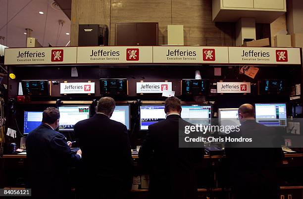 Financial professionals on the floor of the New York Stock Exchange work after hearing news of the Federal Reserve's rate cut December 16, 2008 in...