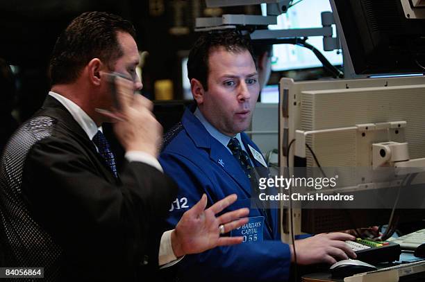 Financial professionals work at a computer terminal on the floor of the New York Stock Exchange at the end of the trading day December 16, 2008 in...