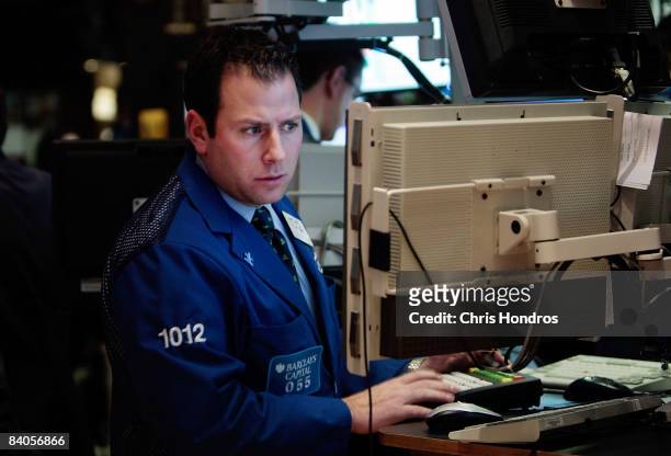 Financial professional works at a computer terminal on the floor of the New York Stock Exchange at the end of the trading day December 16, 2008 in...