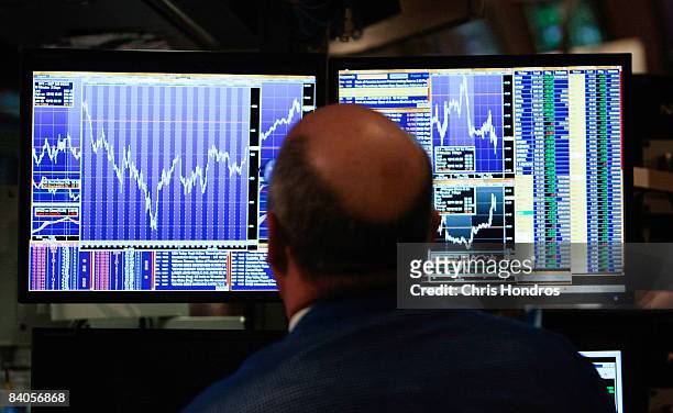 Financial professional loosk at his computer screen on the floor of the New York Stock Exchange at the end of the trading day December 16, 2008 in...