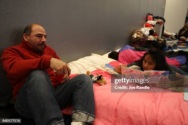 Valeri Delgado reads a book as she and her family take shelter at the George R. Brown Convention Center after flood waters from Hurricane Harvey...