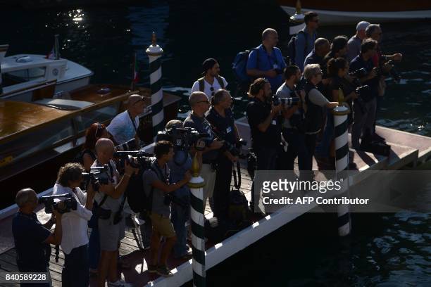 Photographers and cameramen wait for the arrival of taxi-boats transporting celebrities on the eve of the opening ceremony of the 74th Venice Film...