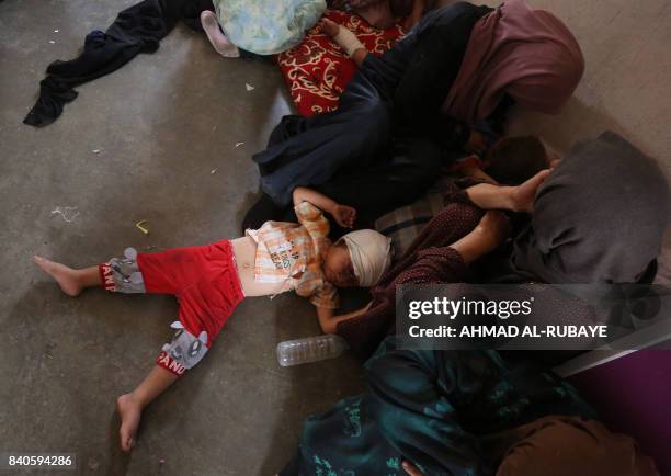 Displaced Iraqi child from Tal Afar lies at a house in Al-Ayadieh village, on August 29 where he got injured as his family was seeking shelter during...