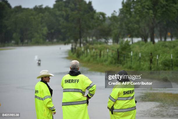 Members of the Sheriff's department stand at the launching point for civilian rescue boats in Cypress, Texas on August 29, 2017. President Donald...