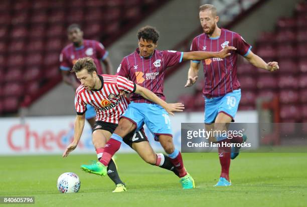 Adam Matthews of Sunderland is tackled by Duane Holmes of Scunthorpe during the Checkertrade Trophy group stage match at Glanford Park on August 29,...