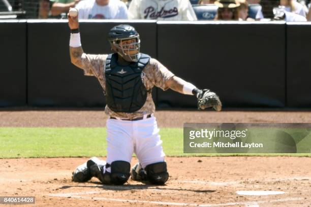 Hector Sanchez of the San Diego Padres throw back to the pitch during a baseball game against the Washington Nationals at Petco Park on August 20,...
