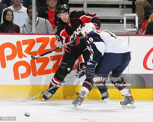 Jason Spezza of the Ottawa Senators passes the puck against Marty Reasoner of the Atlanta Thrashers at Scotiabank Place on December 16, 2008 in...