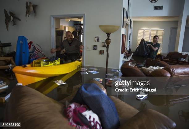 Larry Koser Jr. And his son Matthew look for important papers and heirlooms inside Larry Koser Sr.'s house after it was flooded by heavy rains from...