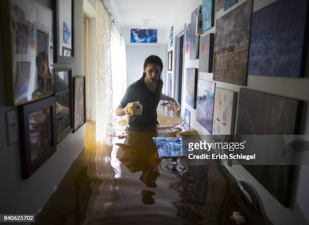 Matthew Koser looks for important papers and heirlooms inside his grandfather's house after it was flooded by heavy rains from Hurricane Harvey...