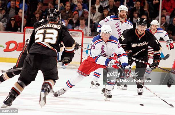 Lauri Korpikoski of the New York Rangers drives the puck through Brett Festerling and Chris Kunitz of the Anaheim Ducks during the game on December...