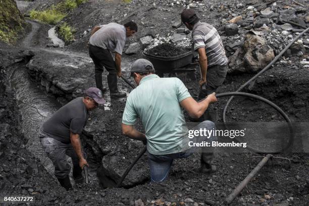 Independent miners, know as guaqueros, sift through mud and rocks searching for emerald that have been washed downstream from the mines in Muzo,...