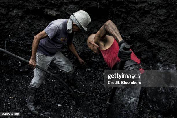 Independent miners, know as guaqueros, sift through mud and rocks searching for emerald stones that have been washed downstream from the mines in...