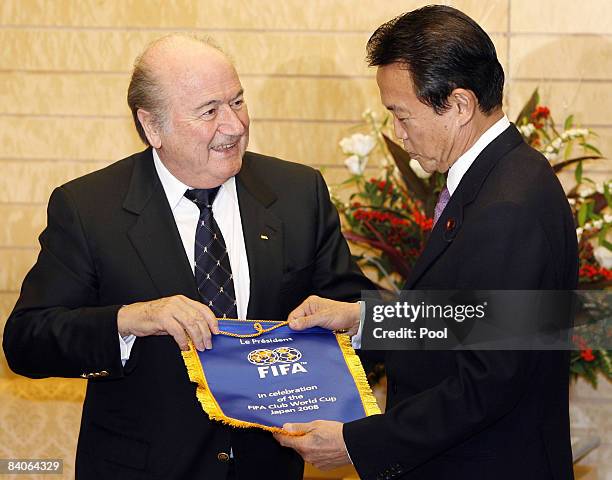 President Sepp Blatter presents a FIFA Club World Cup 2008 pennant to Japanese Prime Minister Taro Aso during his visit to the prime minister's...
