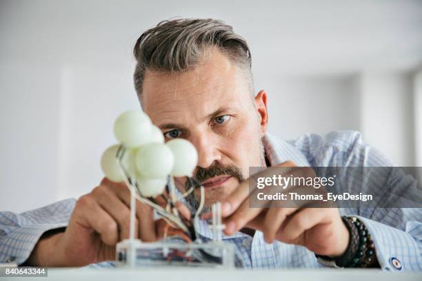 ontwerper te concentreren terwijl het zorgvuldig opbouwen van mockup - industriële vormgever stockfoto's en -beelden