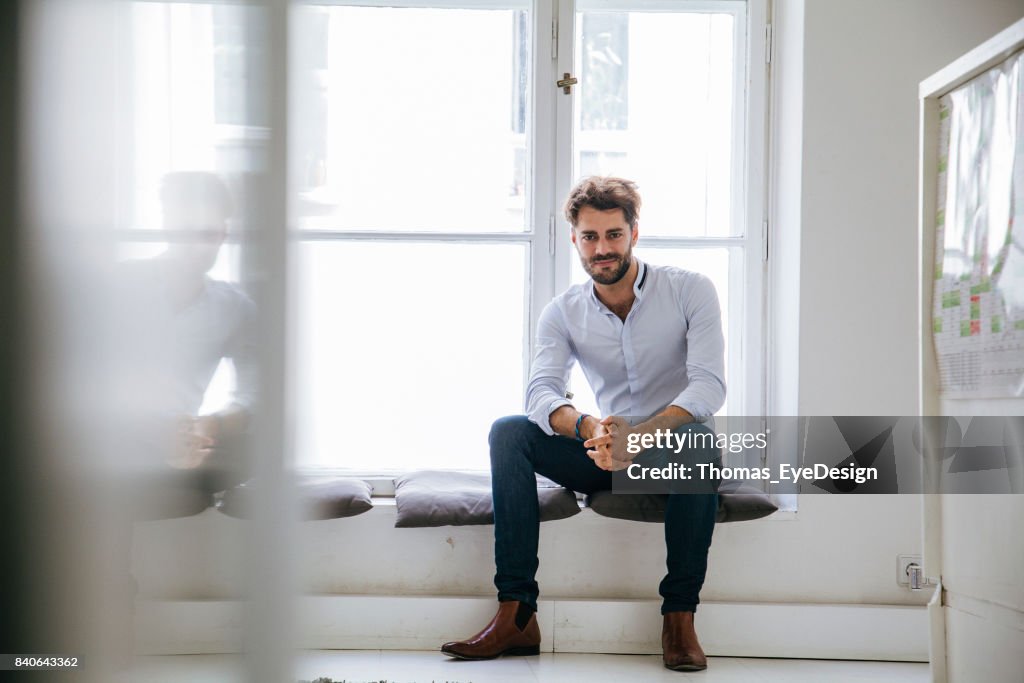 Portrait Of Stylish Office Manager Sitting By Window