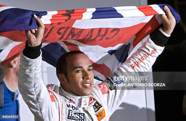 British Formula One driver Lewis Hamilton waves his national flag to celebrate after winning the F-1 World Championship on November 2 at Interlagos...