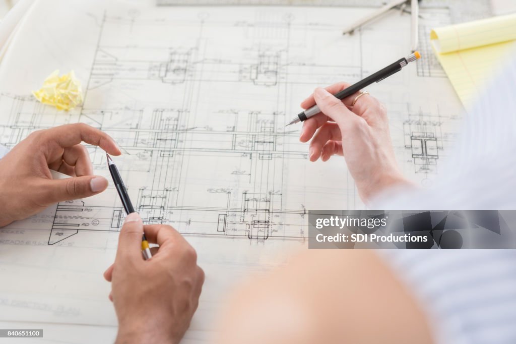 Zwei Sätze von Händen auf architektonische Zeichnung zusammen arbeiten