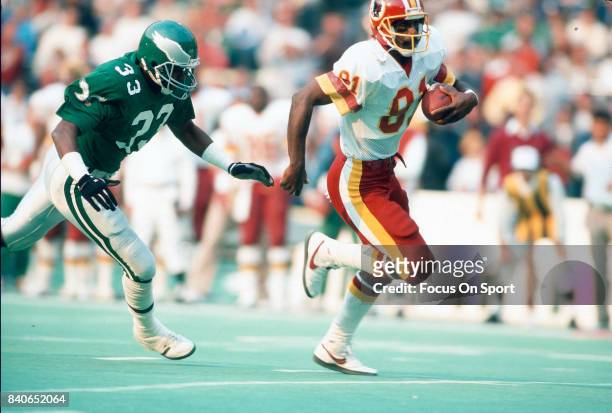 Wide Receiver Art Monk of the Washington Redskins runs with the ball while pursued by William Frizzell of the Philadelphia Eagles during an NFL game...