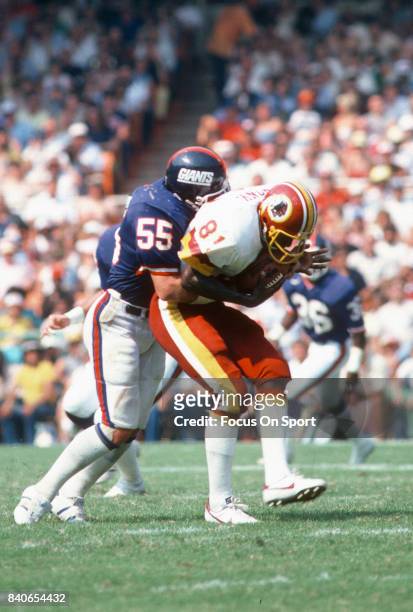 Brian Kelley of the New York Giants tackles Art Monk of the Washington Redskins during an NFL football game December 19, 1982 at RFK Memorial Stadium...