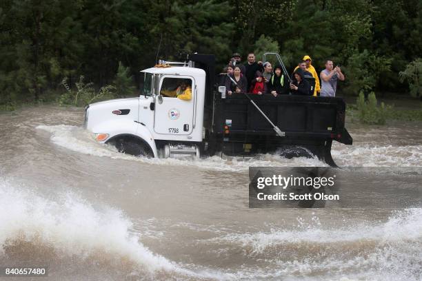 Rescue workers and volunteers help residents make their way out of a flooded neighborhood after it was inundated with rain water following Hurricane...