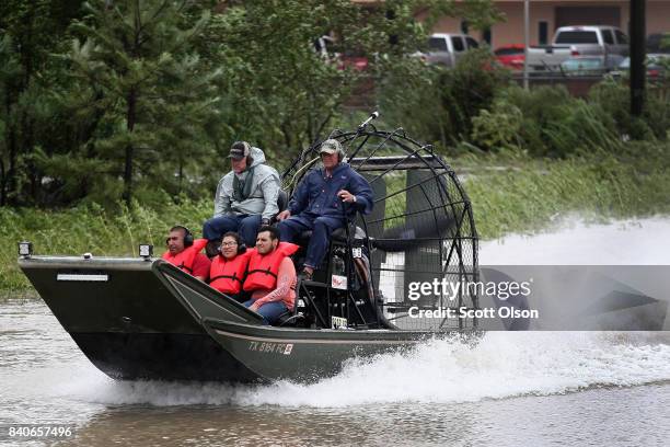 Rescue workers and volunteers help residents make their way out of a flooded neighborhood after it was inundated with rain water following Hurricane...